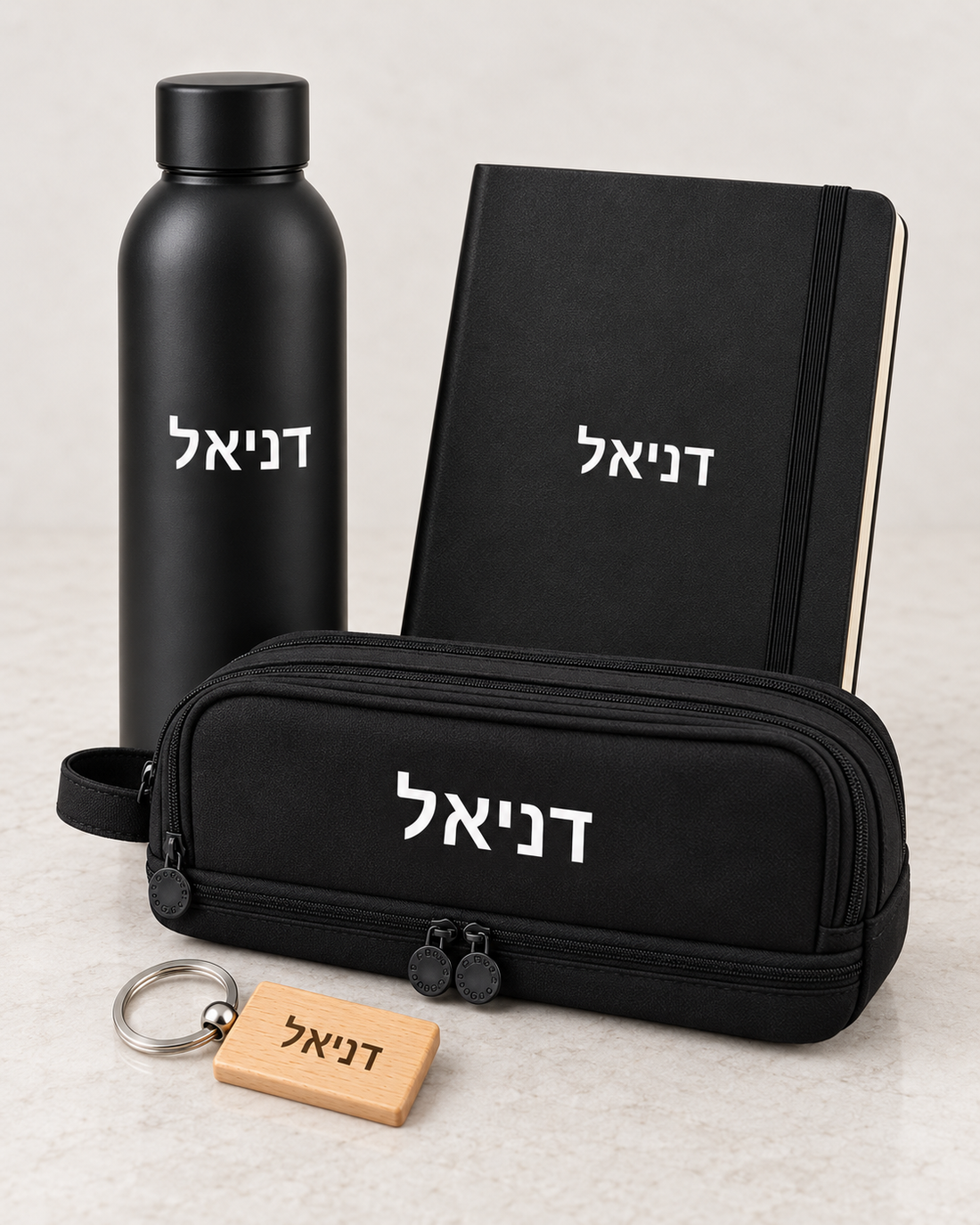 מארז מתנה שחור בהתאמה אישית עם שם – מחברת, בקבוק תרמי, קלמר ומחזיק מפתחות